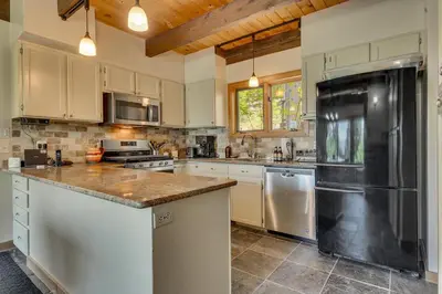 a kitchen with white cabinets and a black refrigerator at Hyphen 5-bedrooms rental, private beach, filtered view in Tahoe City