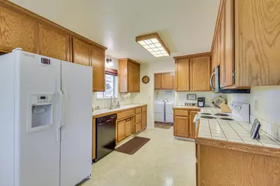 a kitchen with white appliances and wooden cabinets at Yosemite Home Base Community Perks and Lake Access! in Groveland