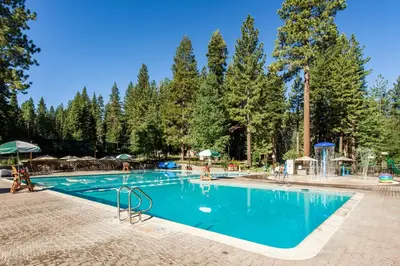 a swimming pool in a resort with trees in the background at Silver Strike Summit in Truckee