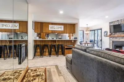 a living room with a couch and a bar at Ground Level, Sunshine Village #171- 2 bed/2 bath, Sleeps 6. Steps from Free Town Shuttle in Mammoth Lakes