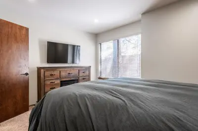a bedroom with a bed and a flat screen tv at Ground Level, Sunshine Village #171- 2 bed/2 bath, Sleeps 6. Steps from Free Town Shuttle in Mammoth Lakes
