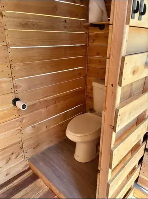 a bathroom with a toilet in a wooden cabin at Secluded Safari Tent Situated in Rural Western El Dorado County Overlooking Majestic Folsom Lake, Northern California in Pilot Hill