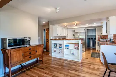 a kitchen with white cabinets and a tv on a counter at Spacious Mountain View Home - Pool, Spa & Game Rm in Oakhurst