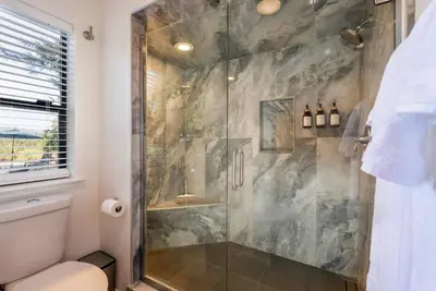 a bathroom with a glass shower with a toilet at Spacious Mountain View Home - Pool, Spa & Game Rm in Oakhurst
