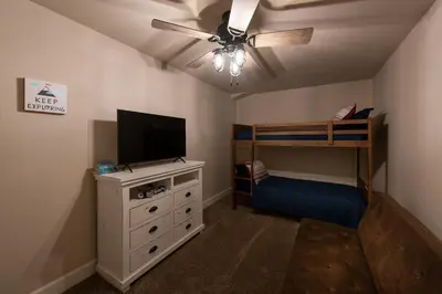 a bedroom with a ceiling fan and a bunk bed at Charming and Relaxing Getaway with Great Views in Shaver Lake