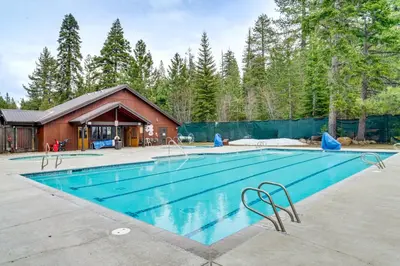 a swimming pool in front of a house at Hike, Sled and Ski! Cozy Tahoe City Condo with Hot Tub in Tahoe City