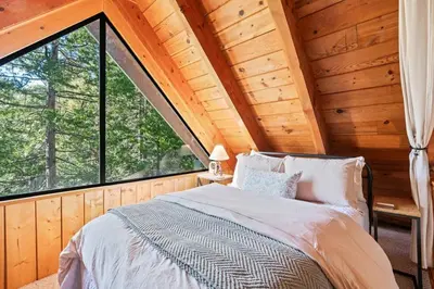a bedroom with a bed and a large window at Piece of Paradise Dream Deck AC in Shaver Lake