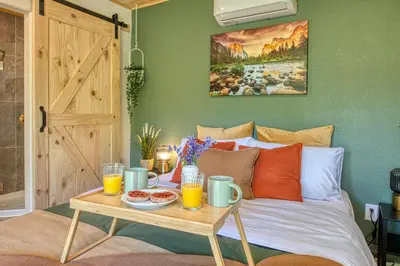 a bed with a table with drinks and food on it at The Mountains are Calling - Private, Guesthouse Retreat near Yosemite in Ahwahnee