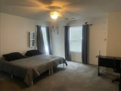 a bedroom with a bed and a ceiling fan at Spacious 4 bedroom house! in Stockton