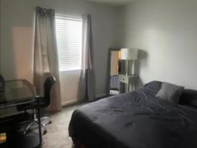 a bedroom with a bed and a desk and a window at Spacious 4 bedroom house! in Stockton