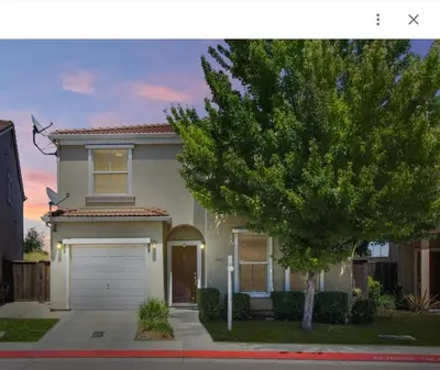 a house with a garage and a tree at Spacious 4 bedroom house! in Stockton