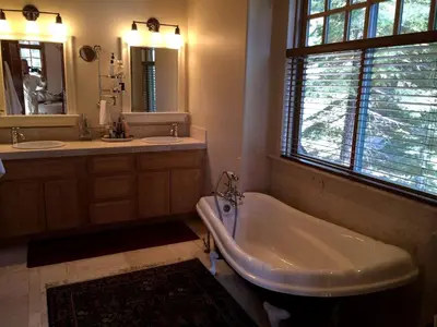 a bathroom with a tub and two sinks and a window at Modern Woodland Cabin Getaway with a Fireplace in Truckee, California in Truckee