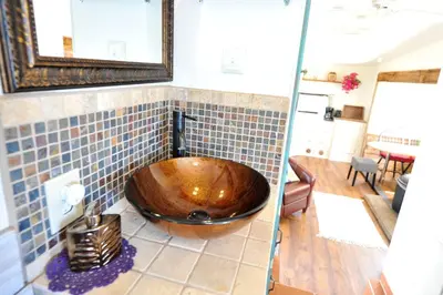 a bathroom with a wooden bowl sink on a tiled wall at Rustic Trailer Rental on the Shores of Bridgeport Reservoir, California in Bridgeport