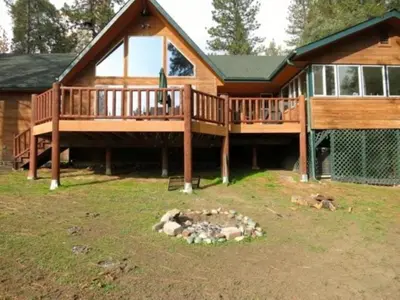 a large house with a deck and a fire pit at Gorgeous Vacation Rental with Hot Tub near Yosemite National Park, California in Mariposa
