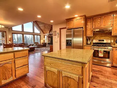 a large kitchen with wooden cabinets and a large island at Gorgeous Vacation Rental with Hot Tub near Yosemite National Park, California in Mariposa