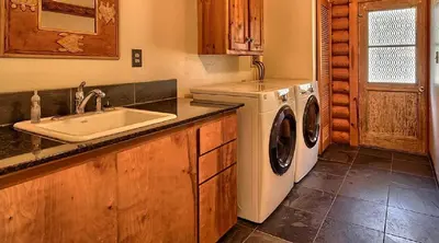 a kitchen with a sink and a washing machine at Cozy Log Cabin near Yosemite National Park in California in Mariposa