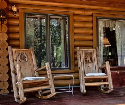 two chairs sitting on the porch of a log cabin at Cozy Log Cabin near Yosemite National Park in California in Mariposa
