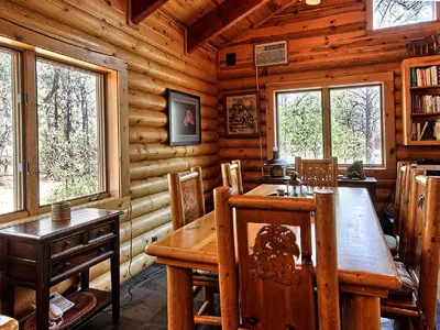 a dining room with a wooden table in a cabin at Cozy Log Cabin near Yosemite National Park in California in Mariposa
