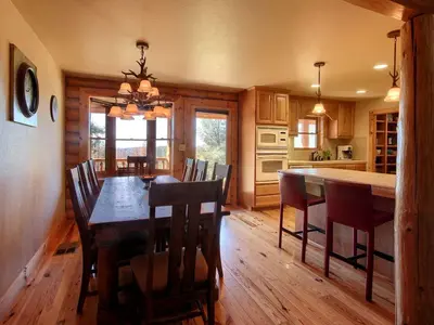 a kitchen and dining room with a wooden table and chairs at Exceptionally Spacious Log Cabin for Groups in Mariposa, California in Mariposa