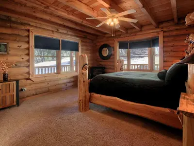 a bedroom with a bed in a log cabin at Exceptionally Spacious Log Cabin for Groups in Mariposa, California in Mariposa