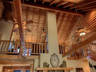 a room with wooden ceilings and a clock on the wall at Exceptionally Spacious Log Cabin for Groups in Mariposa, California in Mariposa