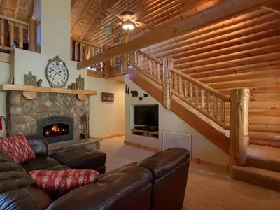 a living room with a couch and a fireplace at Exceptionally Spacious Log Cabin for Groups in Mariposa, California in Mariposa