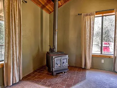 a wood stove in a room with a window at Family-Friendly Cabin near Yosemite National Park in California in Mariposa