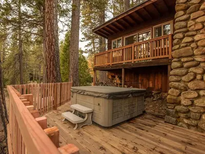 a hot tub on a deck of a house at Cozy Riverside Cabin Rental with Easy Access to Chilnualna Falls in California in Wawona