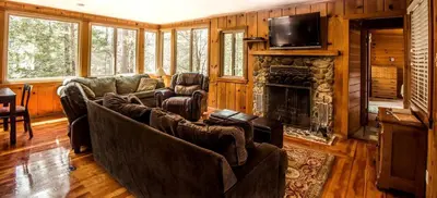a living room with couches and a fireplace at Cozy Riverside Cabin Rental with Easy Access to Chilnualna Falls in California in Wawona