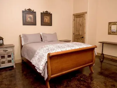 a bedroom with a bed with a wooden frame at Exquisite Cottage Rental on Peaceful Vineyard near Bear Valley, California in Angels Camp