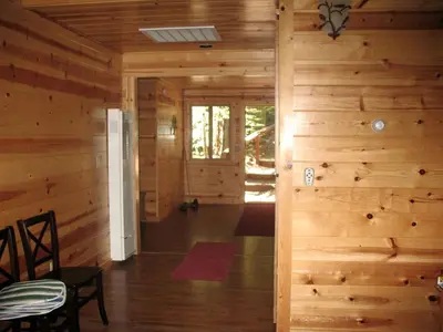 a hallway of a log cabin with a room with wooden walls at Exceptional Riverside Cabin Rental in the Trees near Pinecrest Lake, California in Strawberry