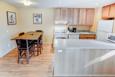 a kitchen with a table and a white refrigerator at San Sierra #16 Hot Tub Sauna Near Skiing in Mammoth Lakes