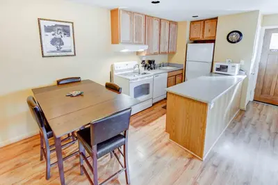 a kitchen with a wooden table and a wooden floor at San Sierra #16 Hot Tub Sauna Near Skiing in Mammoth Lakes