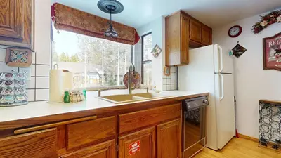 a kitchen with a sink and a refrigerator at Serene Sierra Sanctuary Experience Mammoth Magic in Mammoth Lakes