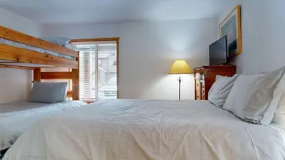 a bedroom with two beds and a tv on the wall at Serene Sierra Sanctuary Experience Mammoth Magic in Mammoth Lakes