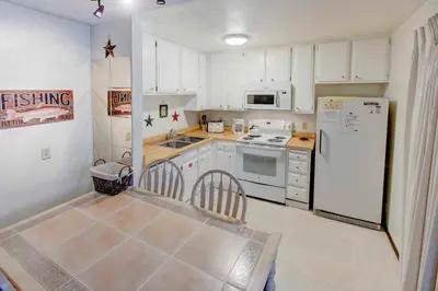 a kitchen with white cabinets and a white refrigerator at Sherwin Villas Free Shuttle & Near Skiing in Mammoth Lakes