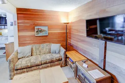 a living room with a couch and a flat screen tv at Sherwin Villas #63 Private Deck & Near Lakes in Mammoth Lakes