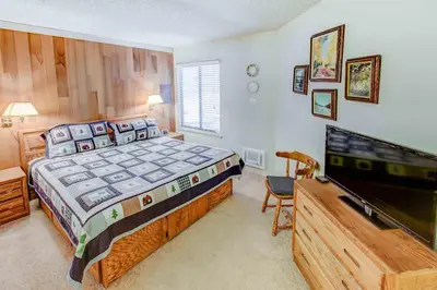 a bedroom with a bed and a flat screen tv at Sherwin Villas #63 Private Deck & Near Lakes in Mammoth Lakes