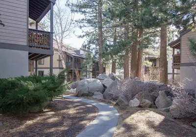 a garden with rocks and a walkway next to a house at Sherwin Villas #63 Private Deck & Near Lakes in Mammoth Lakes