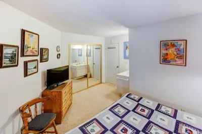 a bedroom with a bed and a television and a bathroom at Sherwin Villas #63 Private Deck & Near Lakes in Mammoth Lakes
