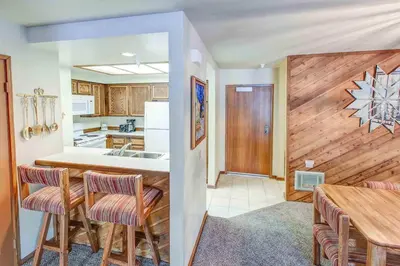 a kitchen with a table and chairs and a counter top at Aspen Creek #113 Family Friendly Condo in Mammoth Lakes