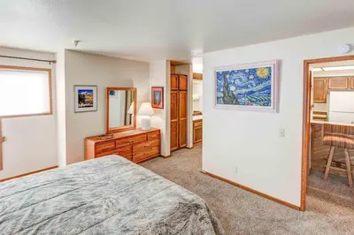 a bedroom with a bed and a dresser and a mirror at Aspen Creek #113 Family Friendly Condo in Mammoth Lakes