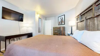 a bedroom with a large bed with a tv on the wall at Sherwin Villas Retreat DT in Mammoth Lakes