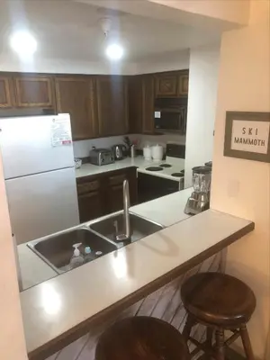 a kitchen with a sink and a white refrigerator at Aspen Creek #114 Near Year-Round Activities in Mammoth Lakes