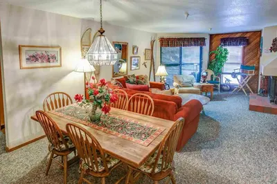a living room with a table and a couch at Aspen Creek #119 Shared Pool Hot Tub & BBQ in Mammoth Lakes