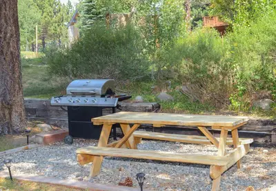 a picnic table and a grill in a yard at Aspen Creek #119 Shared Pool Hot Tub & BBQ in Mammoth Lakes
