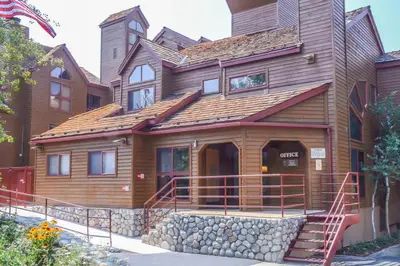 a large wooden house with a staircase in front of it at Aspen Creek #204 Near Golf Fishing & Hiking in Mammoth Lakes