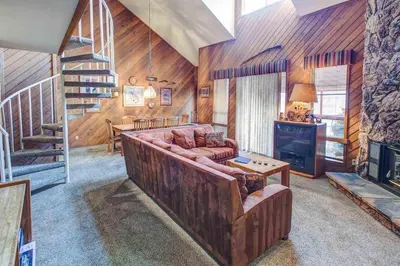 a living room with a couch and a staircase at Aspen Creek #204 Near Golf Fishing & Hiking in Mammoth Lakes
