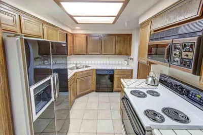 a kitchen with wooden cabinets and a white stove top oven at Aspen Creek #204 Near Golf Fishing & Hiking in Mammoth Lakes