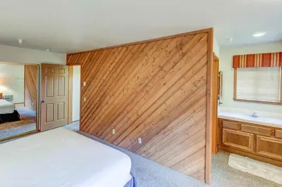 a bedroom with a wooden wall with a bed and a tub at Aspen Creek #204 Near Golf Fishing & Hiking in Mammoth Lakes